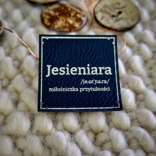 Czarna naszywka Jesieniara ze srebrnym grawerem, 8 dziurek do stabilnego przyszycia na maszynie lub ręcznie.