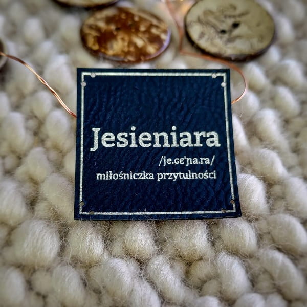 Czarna naszywka Jesieniara ze srebrnym grawerem, 8 dziurek do stabilnego przyszycia na maszynie lub ręcznie.