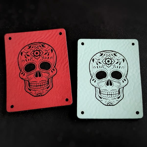 Dwie naszywki z ekoskóry z czaszką Calavera w kolorze czerwonym i jasnoniebieskim na czarnym tle