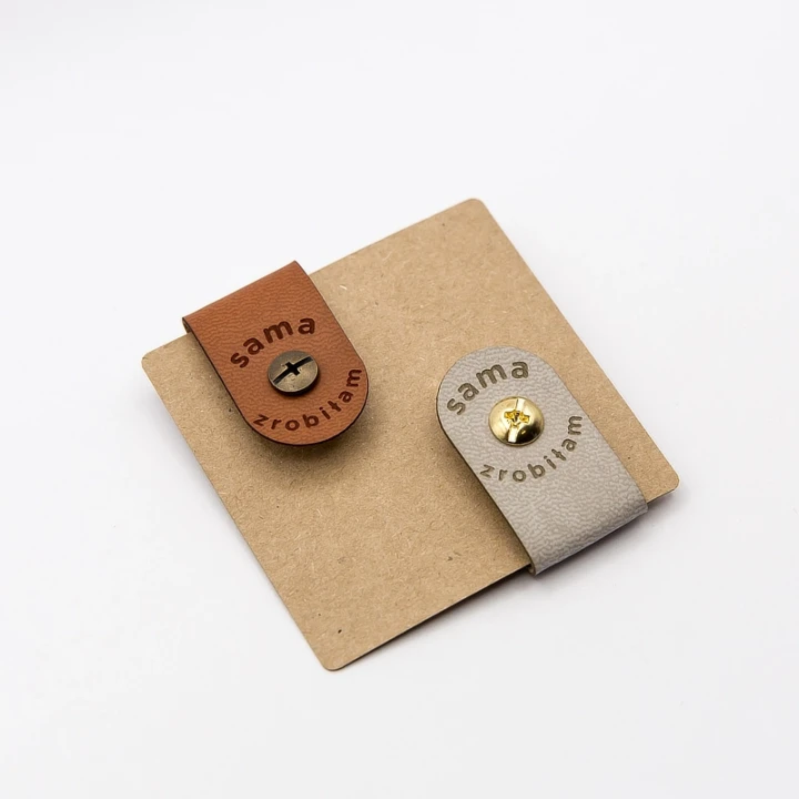 Dwie metki do rękodzieła ze sztucznej skóry w kolorach brązowym i beżowym,  na nity.