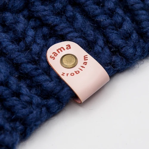 Metka w kolorze jasnego różu z napisem montowana na nit płaski.