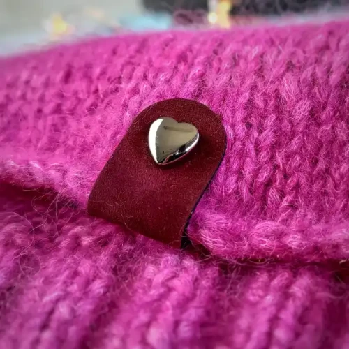Wiśniowa metka Minimal z czarnym nitem-sercem na różowym swetrze o grubym splocie