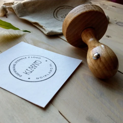 Drewniany stempel z odbitką logo firmy na eleganckim papierze.webp