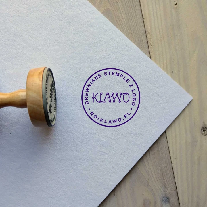 Drewniany stempel z logo firmy i wyraźna, fioletowa odbitka wykonana tuszem na bazie wody.webp